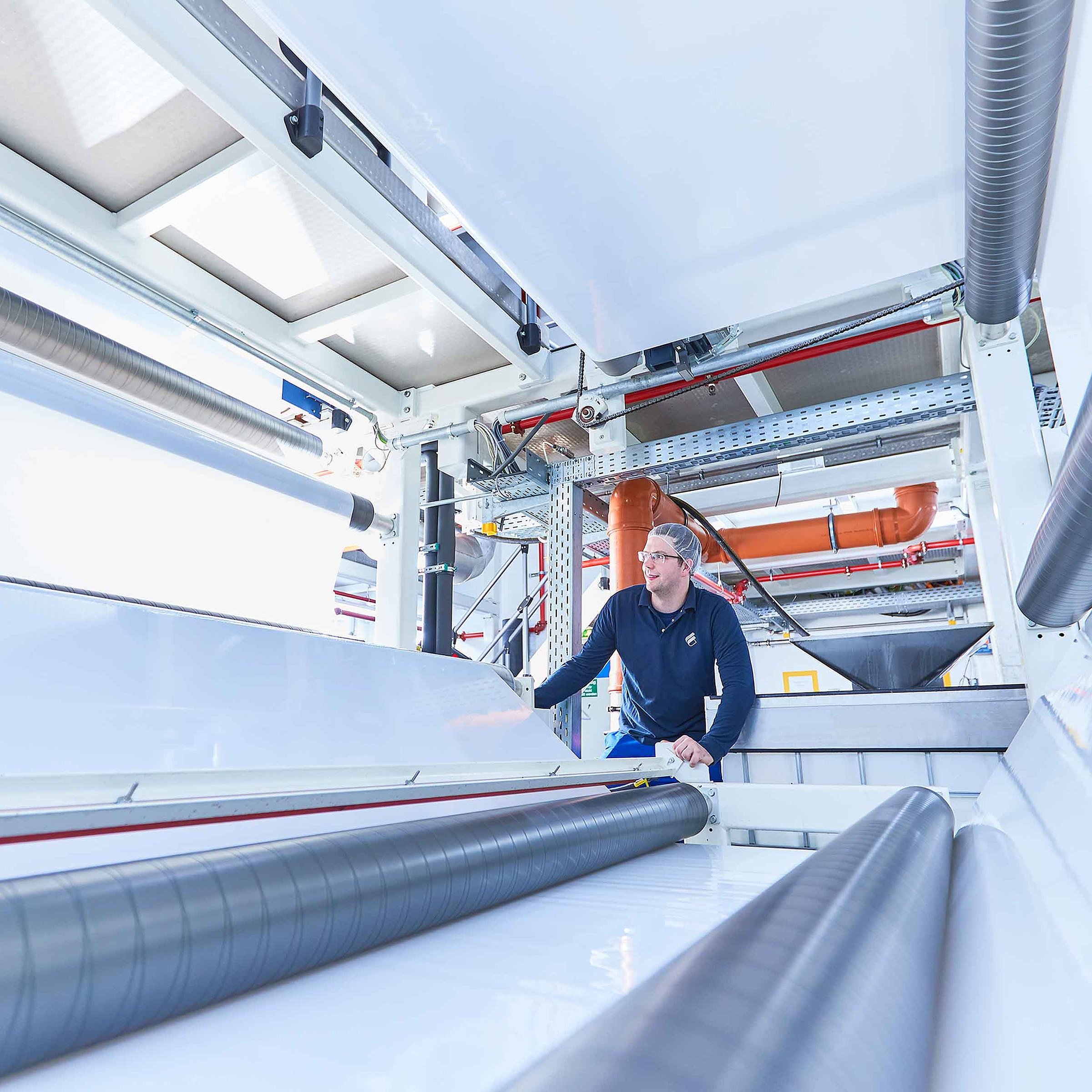 A production employee is checking the product quality on a machine