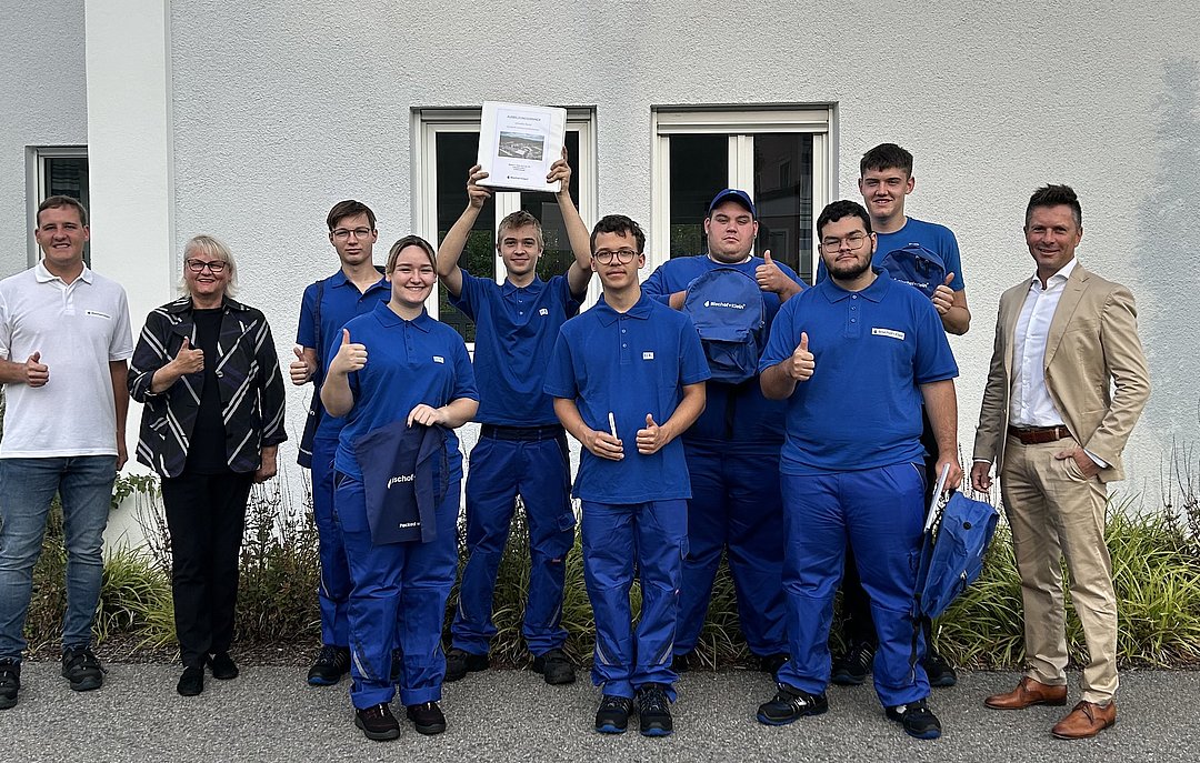 Seven new trainees in Konzell with training manager Wolfgang Schollerer and plant manager Armin Kienberger. The trainees are wearing blue Bischof+Klein T-shirts and blue work pants