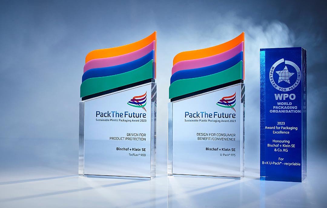 Zdjęcie z trzema nagrodami zdobytymi w 2023 roku: World Star Packaging Award dla opakowania U-Pack® nadającego się do recyklingu, Pack The Future Award dla opakowania U-Pack® ffs oraz Pack The Future Award dla opakowania TacFlex® 900. Nagrody stoją obok siebie na ciemnym tle i są podświetlone.