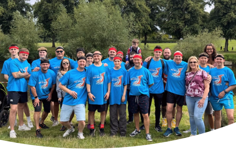 Einige Kollegen von unserem Standort in der UK. Sie tragen ein blaues T-Shirt mit einem Drachenlogo. Das Foto ist nach dem Bootsrennen entstanden